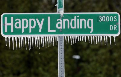 Icicles hang from a street sign after a fast moving snow storm blanketed central Illinois, Friday, Feb. 22, 2013, in Springfield, Ill. Powerful wind gusts created large snow drifts on many roadways, making navigating the slick conditions a challenge. Accidents and slide-offs were reported from Kansas to Michigan as the storm pushed east. (AP Photo/Seth Perlman)