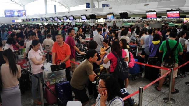 Passengers queue to register at an airline counter as Typhoon Usagi approaches at Hong Kong airport on Sept. 22, 2013. (AFP/Getty Images)