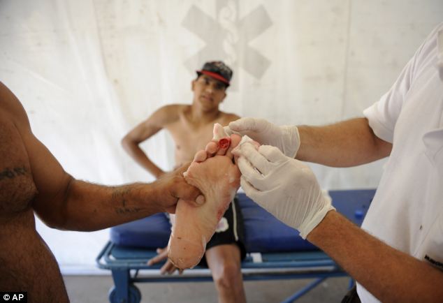 Dec. 25, 2013: A man is treated after he was bit by a palometa, a type of piranha, while wading in the Parana River in Rosario, Argentina. Lifeguards director Federico Cornier said Thursday that thousands of bathers were cooling off from 100 degree temperatures in the Parana River on Wednesday when bathers suddenly came to them complaining of bite marks on their hands and feet. He blamed the attack on palometas, a type of piranha, big, voracious and with sharp teeth that can really bite. (AP/LA CAPITAL) 