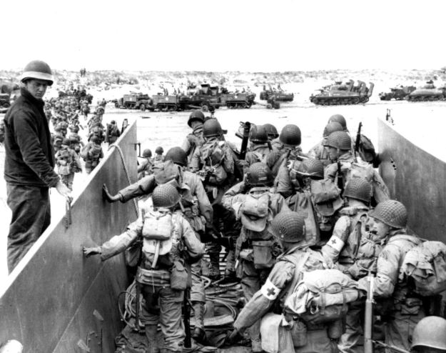 Under heavy German machine gun fire, American infantrymen wade ashore off the ramp of a Coast Guard landing craft on June 6, 1944. (PA) 